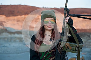 Armed girl on the background of the highlands