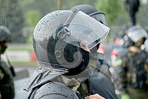 Armed police stand in the pouring rain to disperse the protesters