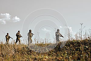 Armed special forces with rifle going against enemies, in row during the military operation