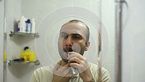Armenian man shaving beard using electric trimmer shaver