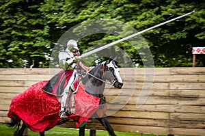 Armored knight on horseback charging in a joust