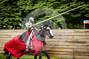 Armored knight on horseback charging in a joust photo