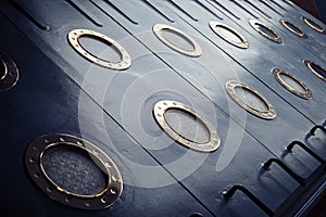 Armored portholes of brass with brass screws.