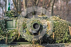 Armoured tank with cannon and camouflage coating