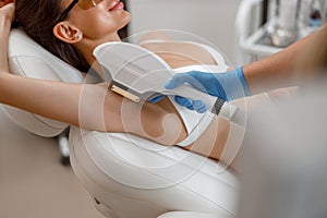 Armpit hair photo epilation procedure with ipl machine in a beauty salon