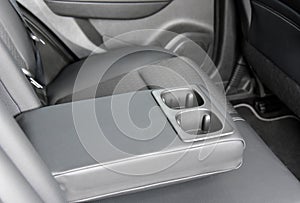 Armrest in the car with cup holder for rear seats row