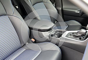 Armrest in the luxury passenger car with cup holder between the front seats