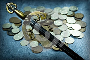 The arms of ancient knightly swords on the background of a scattering of coins.