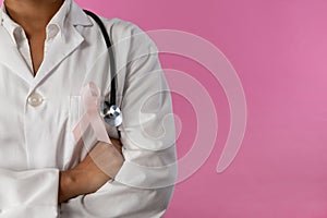 arms crossed nurse wearing breast cancer awareness pink ribbon