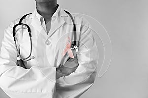 arms crossed nurse wearing breast cancer pink ribbon