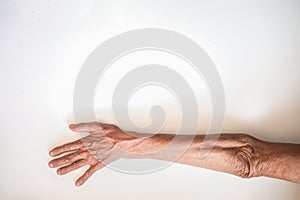 Arms and hands of the elderly man on a white background