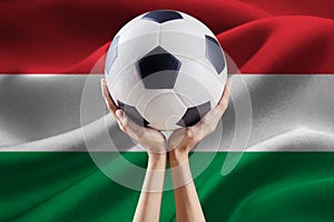 Arms holding ball with flag of Hungary