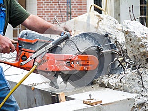 Arms holding grinder cutting concrete