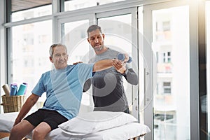 Arms straight out. a young male physiotherapist assisting a senior patient in recovery.