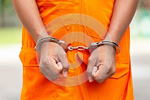 Arms of Thai monk with metal silver handcuff. Arrest the monk or