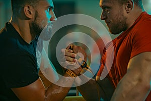 The Armwrestling. Two strong athletes in the gym compete in arm wrestling. Bodybuilders armwreslers in athletic training