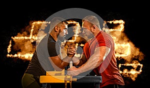 The Armwrestling. Two strong athletes in the gym compete in arm wrestling. Bodybuilders armwreslers in athletic training