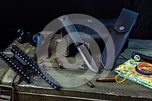 An army black knife with a fixed blade. Knife and leather sheath. Optical sight and sleeves. photo