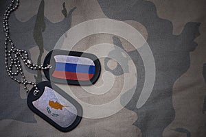 army blank, dog tag with flag of russia and cyprus on the khaki texture background.