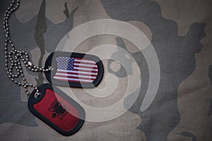 army blank, dog tag with flag of united states of america and albania on the khaki texture background.