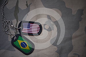 army blank, dog tag with flag of united states of america and brazil on the khaki texture background.