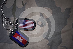 army blank, dog tag with flag of united states of america and cambodia on the khaki texture background.