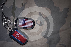 army blank, dog tag with flag of united states of america and north korea on the khaki texture background.