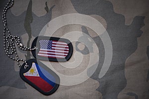army blank, dog tag with flag of united states of america and philippines on the khaki texture background.
