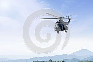 Army helicopter flying over mountains