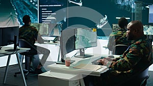 Army intelligence specialists using advanced computer systems and satellite data