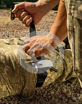 Army medics practice applying a tourniquet to the leg of a wounded soldier.