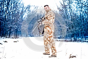 Army sniper during military operation using a professional rifle on a cold winter day