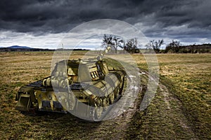 Army tank on the muddy field under the dramatic sky.