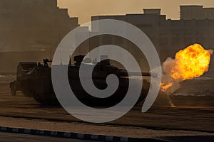 Army tanks shooting and driving in the desert town in war and military conflict. Military concept of war and explosions