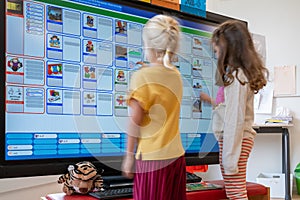 ARNHEM / NETHERLANDS - AUGUST 28 2020:  Children in school standing in front of a touch screen monitor