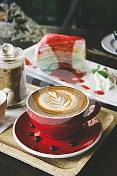 Aroma coffee red cup latte art and tasty cake on wood table in c