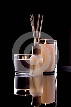 Aroma diffuser and scented candles on table with reflectio. Romantic setting