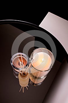 Aroma diffuser and scented candles on table with reflectio. Romantic setting
