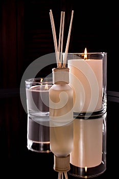 Aroma diffuser and scented candles on table with reflectio. Romantic setting
