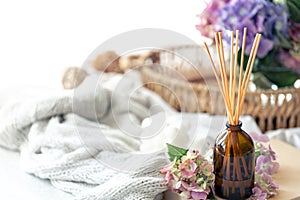 Aroma diffuser with the stick perfume, knitted element and flowers.