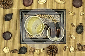 Aroma lamp with essential oil and potpourri on wooden bamboo mat background