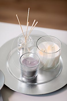 Aroma reed diffuser an candles burning on tray