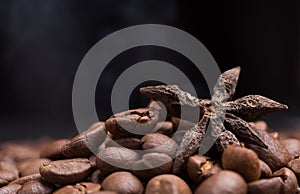 Aroma roasted coffee beans and star anis with smoke rising over dark background
