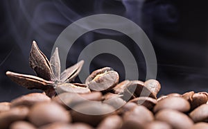 Aroma roasted coffee beans and star anis with smoke rising over dark background