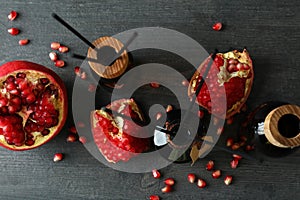Aroma scent diffusers and pomegranate on dark wooden photo