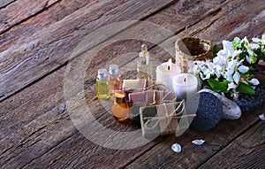 Aroma spa background with handmade soap, aroma candles, flowers, aromatic oils and stones on the wooden background