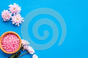 Aroma therapy with pink flower fragrance and spa salt on blue background top view space for text