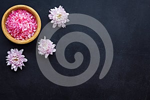 Aroma therapy with pink flower fragrance and spa salt on dark background top view space for text