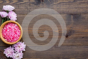 Aroma therapy with pink flower fragrance and spa salt on wooden background top view space for text