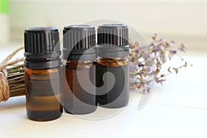 Aromatherapy. Jars of essential oils and a bouquet of lavender flowers on a white background.